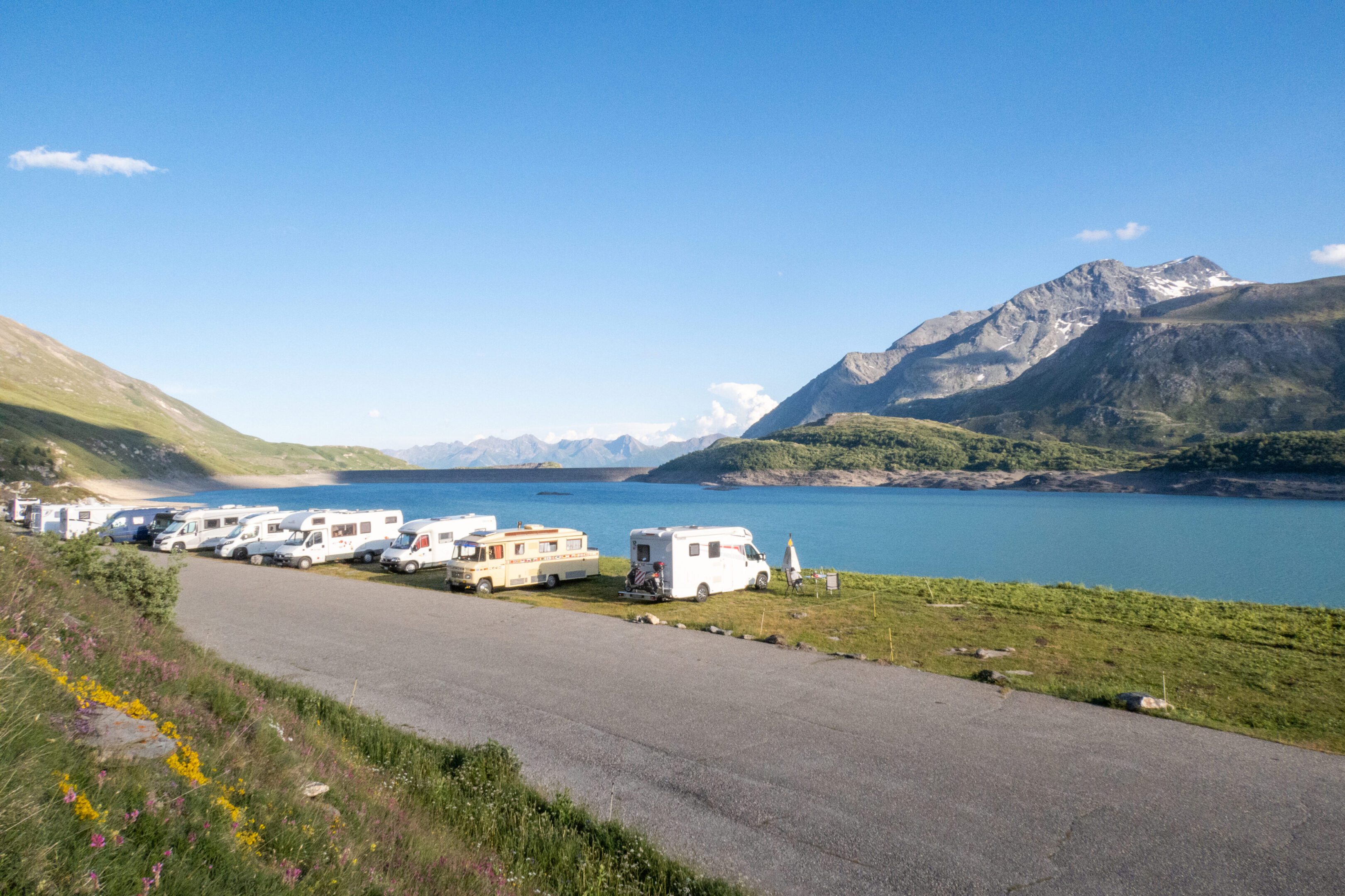 Campers parked by a mountain lake.